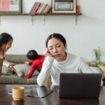 Madre agotada apoyando la cabeza, representando la fatiga parental en familias neurodivergentes