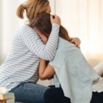 Mamá abrazándose a sí misma en un momento de duelo cíclico por la crianza neurodivergente de su hijo